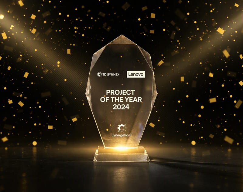 A glowing glass Project of the Year 2024 trophy with the TD SYNNEX, Lenovo and Synergetic IT logos, among golden confetti on a dark background.