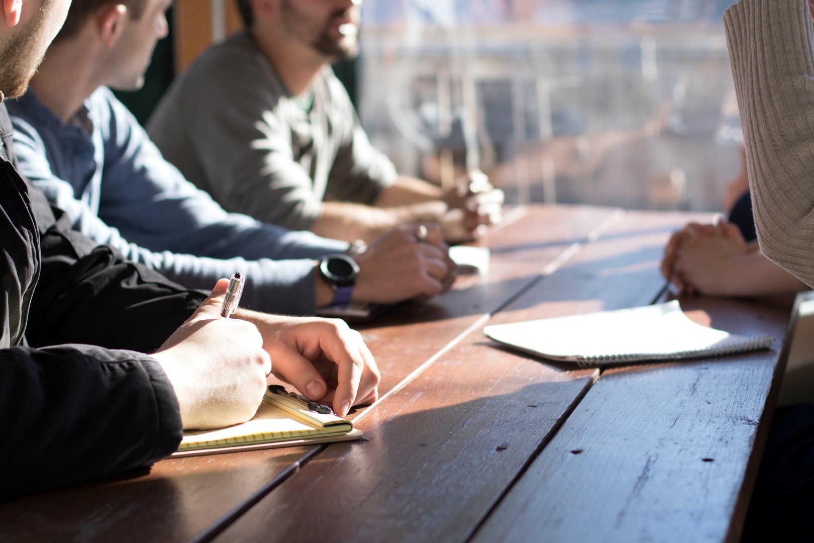 Team sitting at a meeting table discussing some subject. The picture represents a collaboration between people.